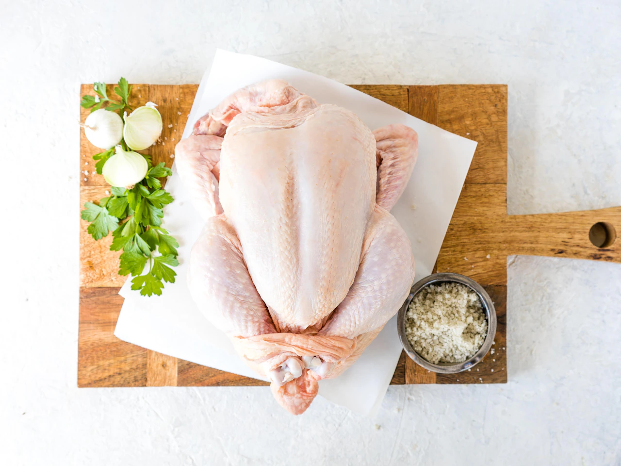 Ayam utuh mentah di atas talenan dengan bumbu