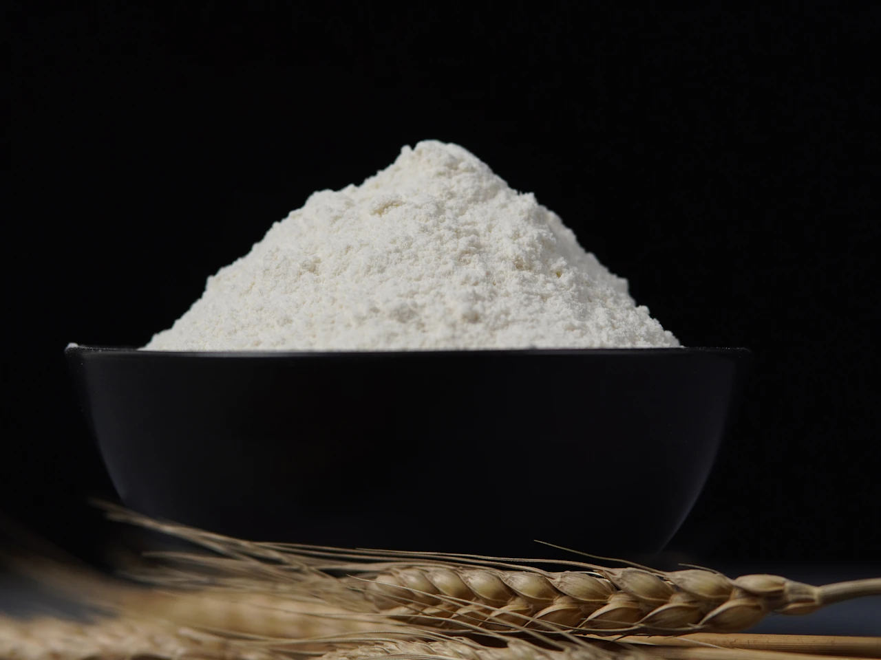 Tepung putih di dalam mangkuk dengan tangkai gandum